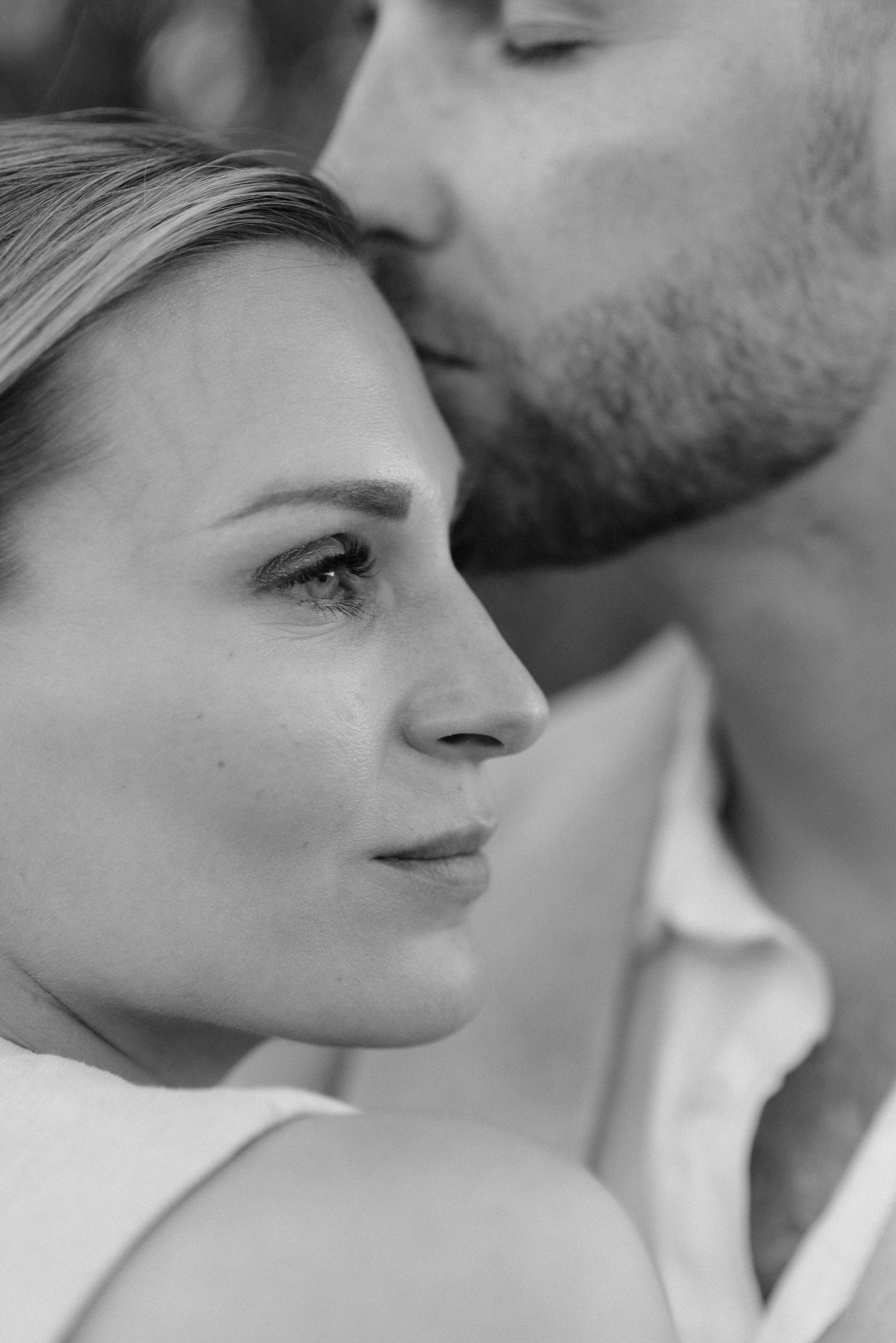 Intimate black and white portrait capturing a tender romantic moment between a couple.