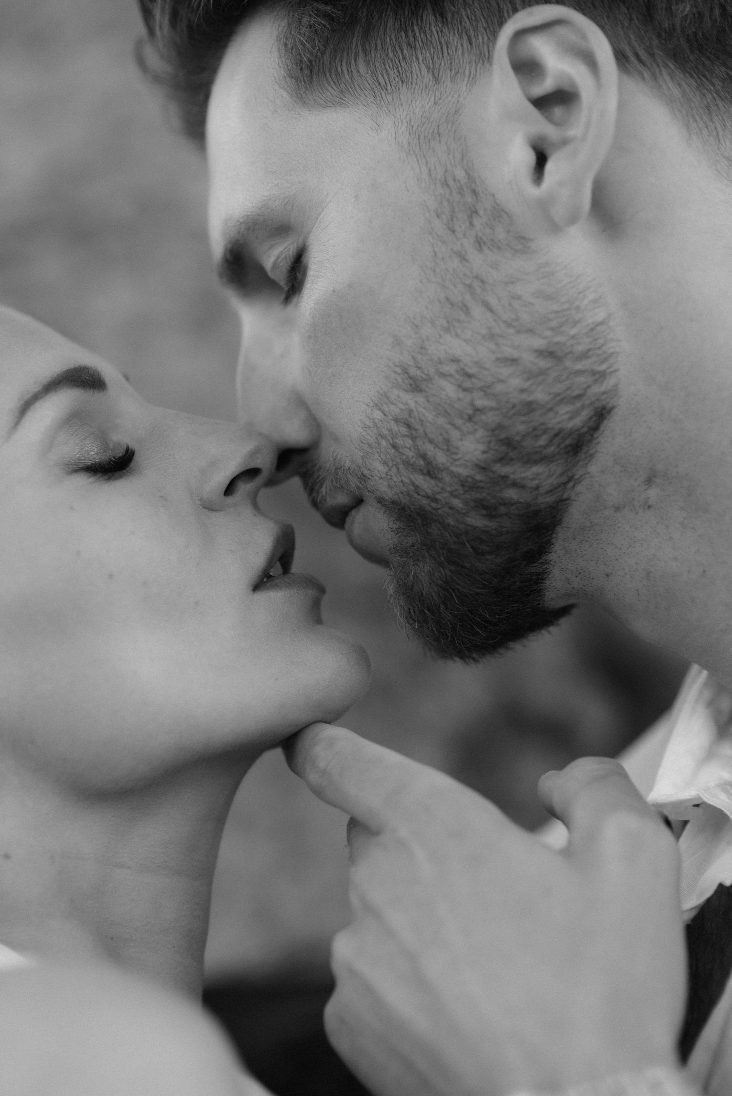 A collection of intimate black and white close-up shots capturing romantic kisses between a couple.