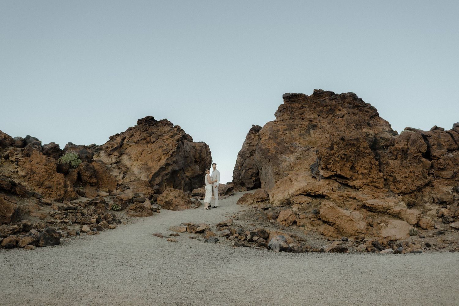 A rocky desert landscape with rugged cliffs and a dirt path.