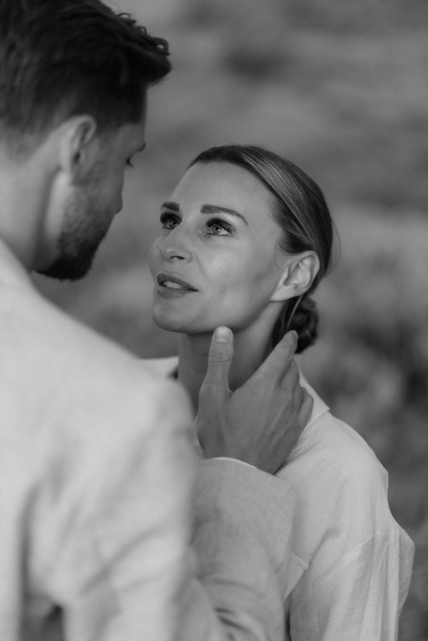 Intimate black and white portrait capturing a tender moment between two people.