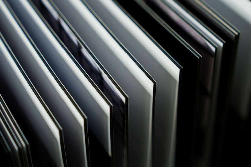 Close-up photograph of stacked paper sheets or documents creating diagonal lines and shadows.