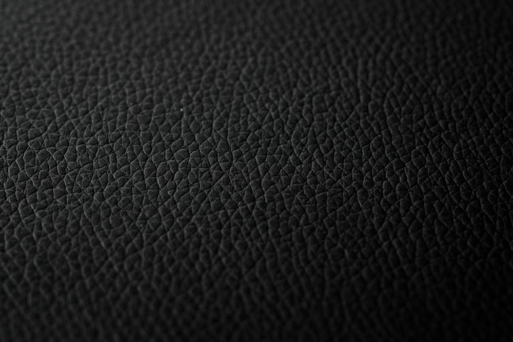 Close-up macro photo of black leather texture showing fine grain pattern detail.