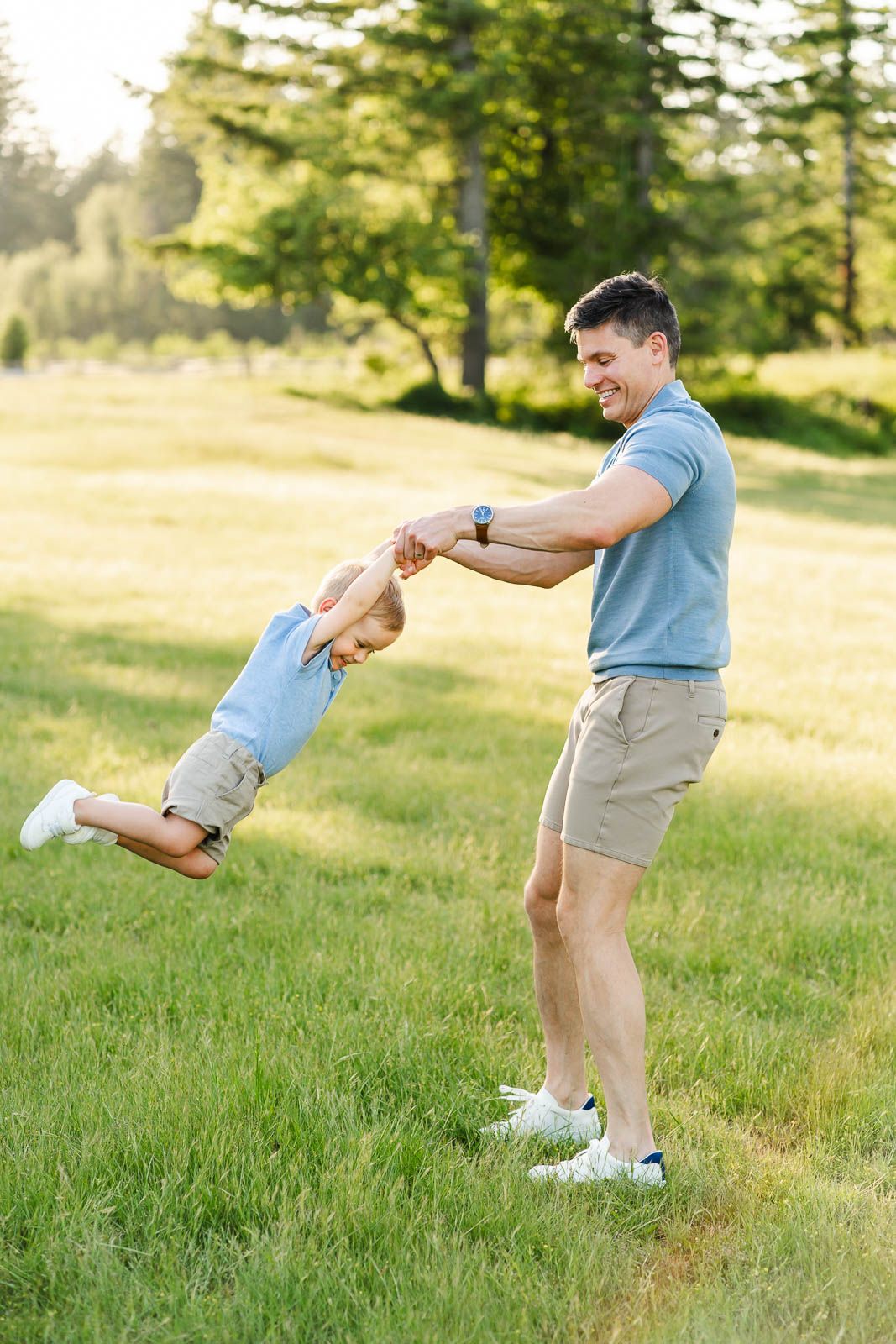 Dad spins his son in a grassy field at Tanner Landing Park.
