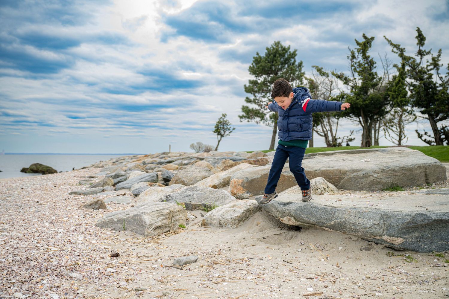 Children explore on horizontal climbing wall at White Mountains Franconia Ridge mount in New Hampshire on sunny day.