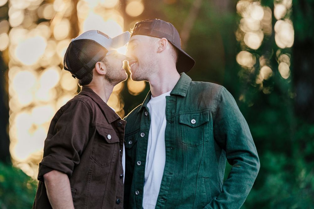 A tender romantic moment captured in golden sunlight with natural bokeh effects in the background.