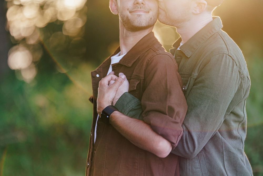 Golden-hour backlit couple in an intimate embrace shares a romantic dance together in a sunlit outdoor setting.