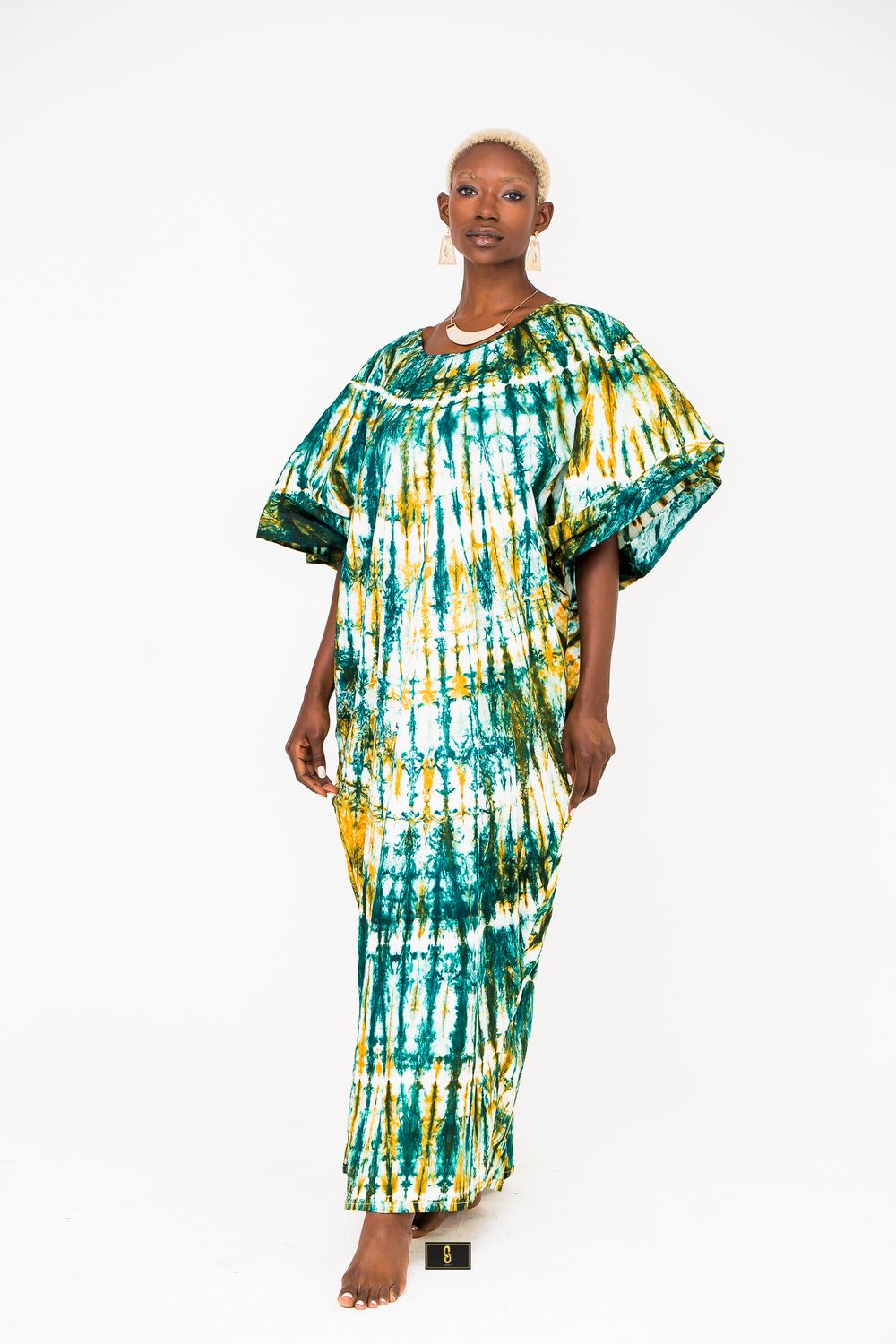 Model wearing green and yellow tie-dye maxi dress with dramatic bell sleeves.