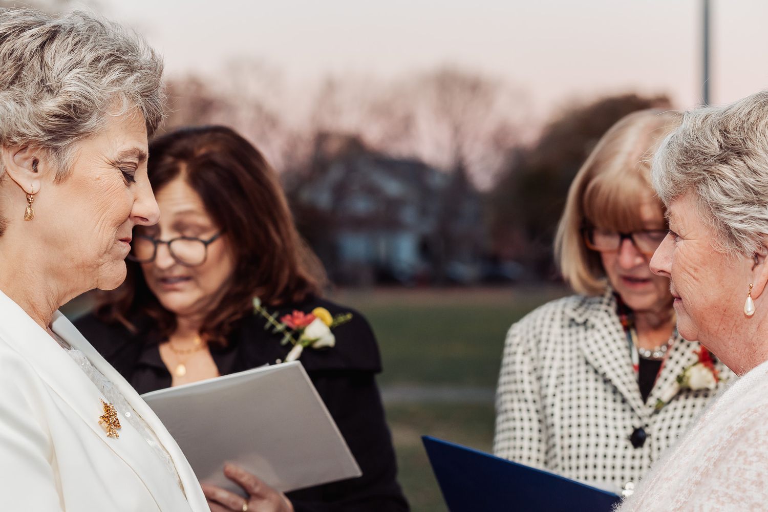 Group gathered for outdoor ceremony reviewing official documents together.