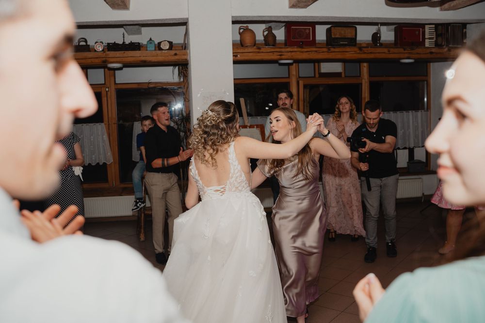 Wedding reception guests dance and celebrate together on the dance floor during a joyful evening celebration.