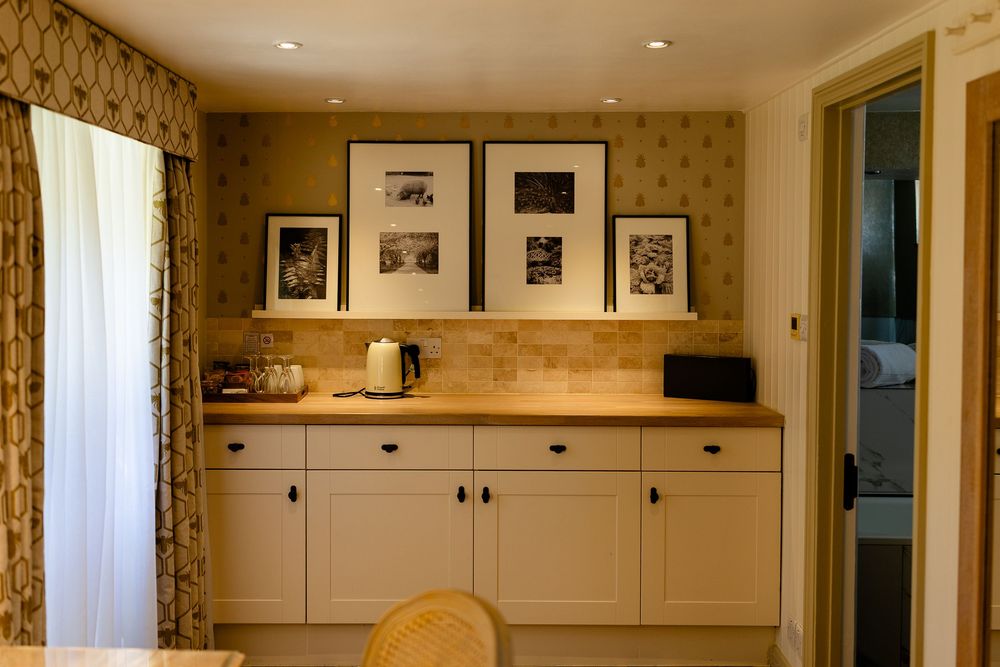 Built-in cream cabinetry with wood countertop and framed artwork display in cozy dining room interior.