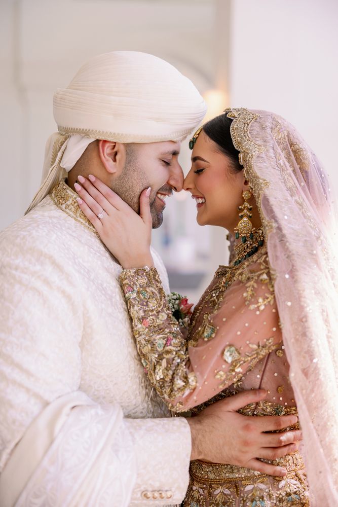 Intimate moment between wedding couple in luxurious traditional South Asian wedding attire.