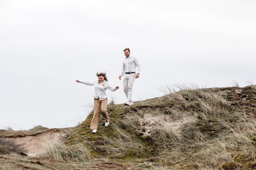 samen springen van de duinen tijdens fotoshoot