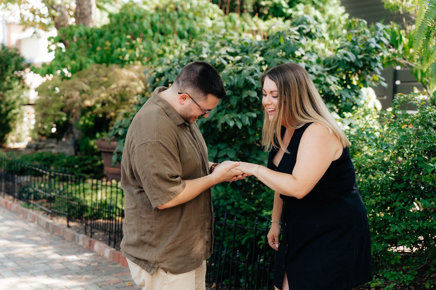 A couple sharing an intimate moment in a garden setting while holding hands.