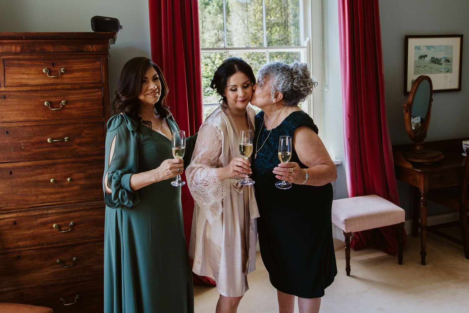 A series of wedding preparation candid moments in front of wooden cabinets with red curtains.