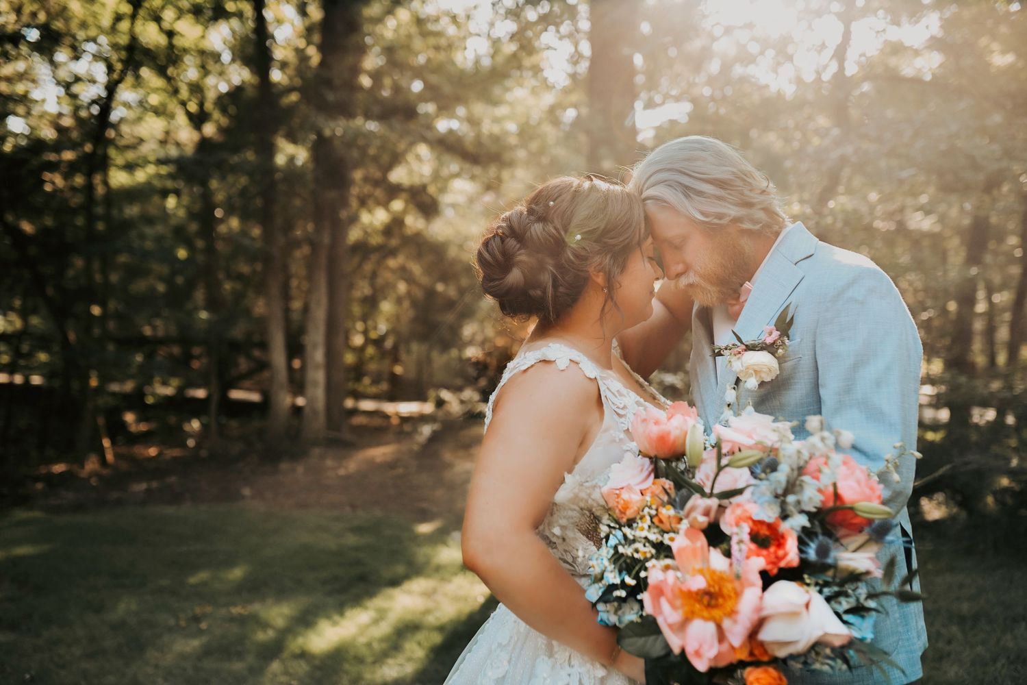Romantic forest portrait of bride and groom surrounded by tall trees