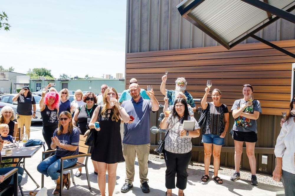 A line of people waiting eagerly outside a building entrance during a community event or gathering.
