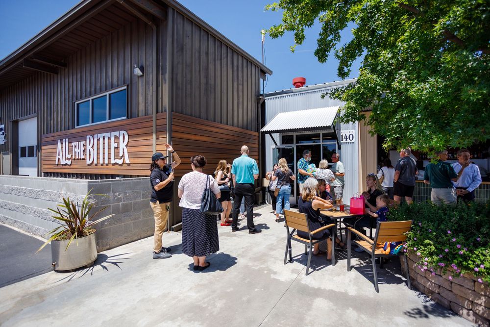 Exterior view of a modern wooden building with outdoor seating and visitor areas.