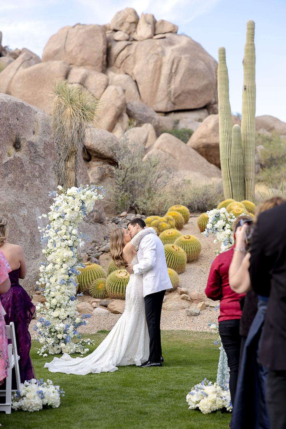 Desert wedding ceremony setup with saguaro cacti and large rock formations in the background.