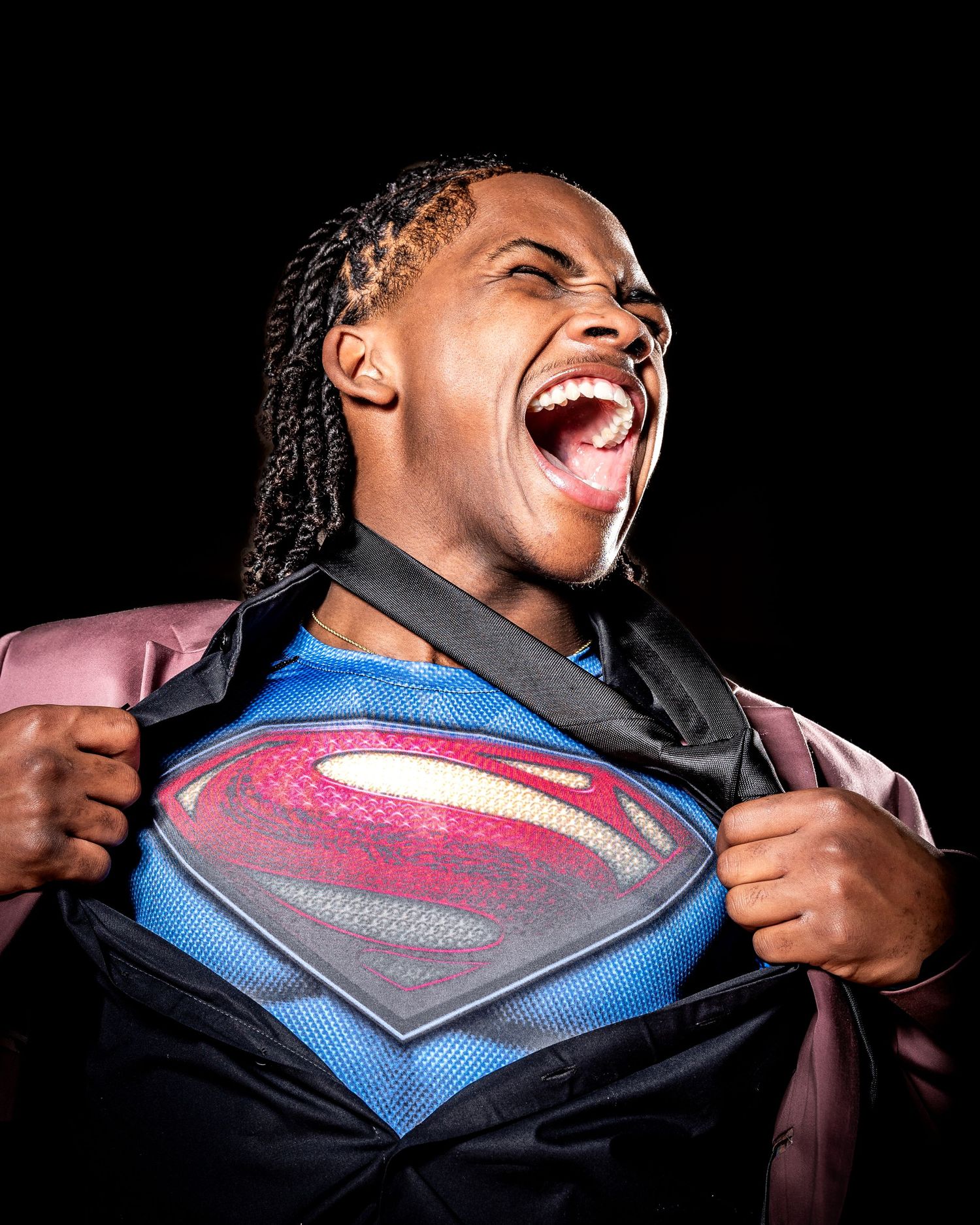 High school senior pulling open Superman shirt during dramatic sports portrait session in Clyde, Ohio