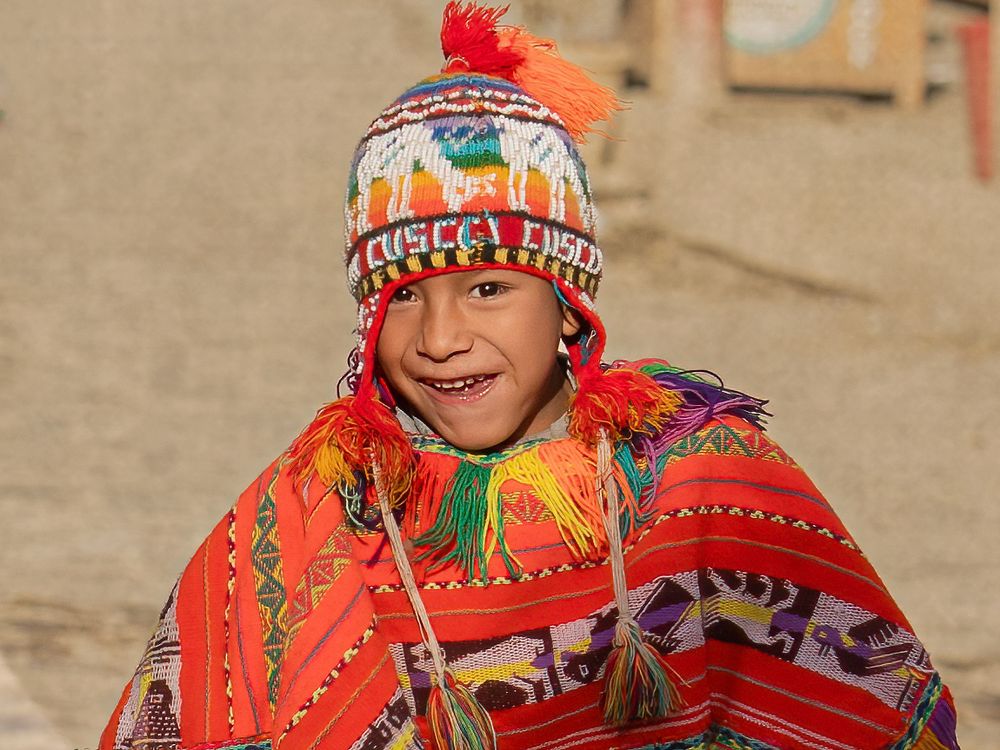 Traditional Peruvian textiles and clothing feature vibrant red ponchos with colorful woven patterns and details.