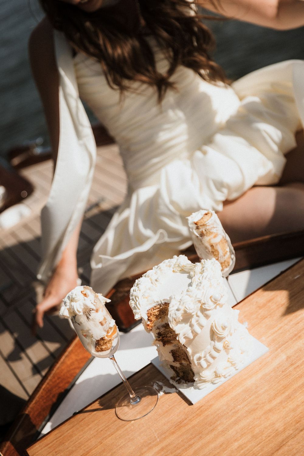 A sequence of a figure dressed in white cutting into what appears to be dessert or cake on a wooden surface.