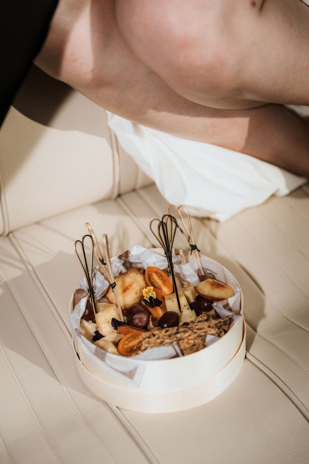 A decorative dessert display with pastries and metal wire accents on white boat seating.