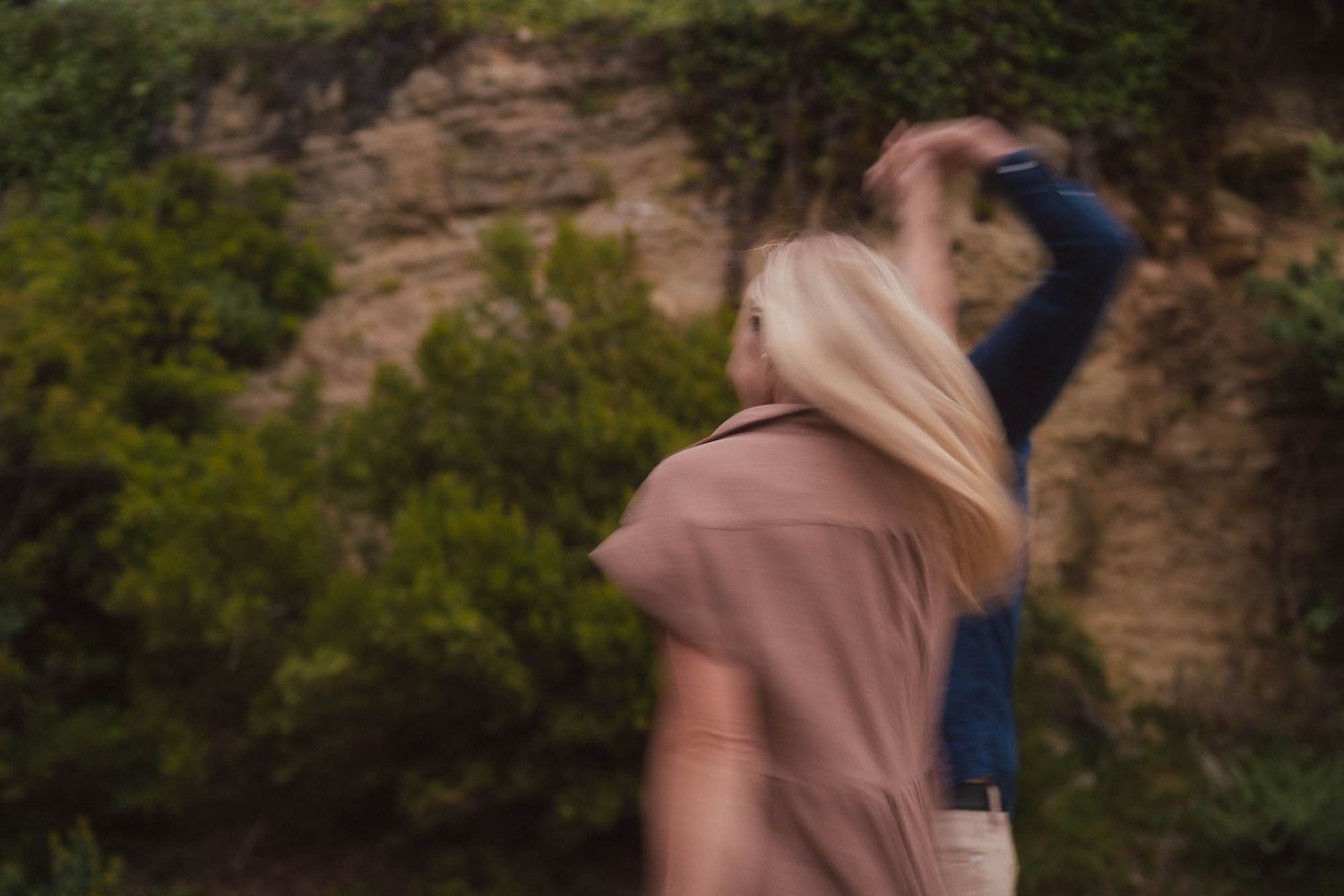 Person in beige outfit swings and spins across multiple frames showing a flowing dance movement sequence in nature.