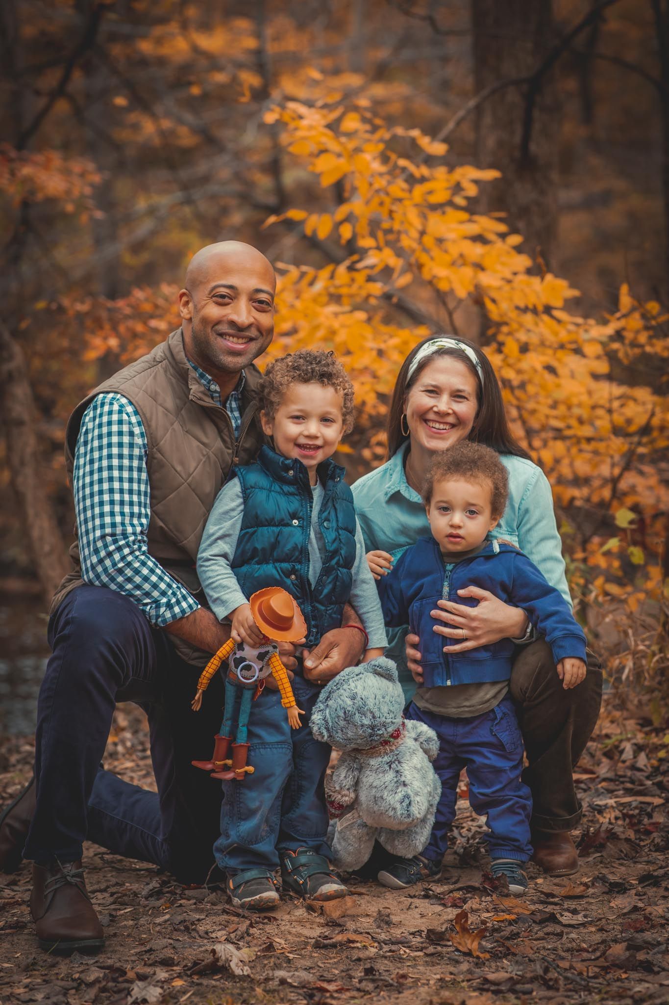 Family of four posing for fall foliage mini photoshoot at Rock Creek Park in Washington DC