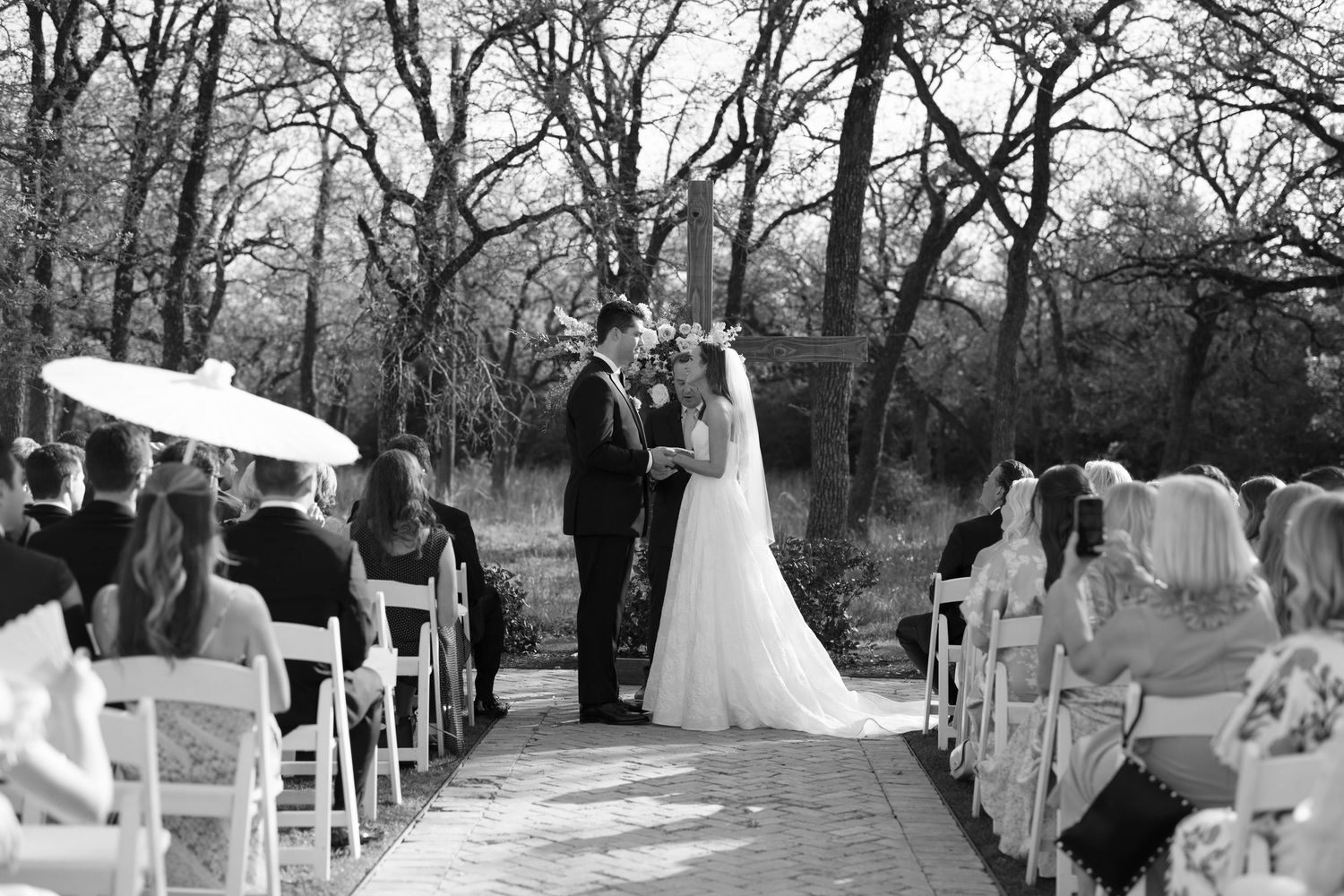 A series of black and white wedding photos show various ceremony moments in an outdoor garden setting.