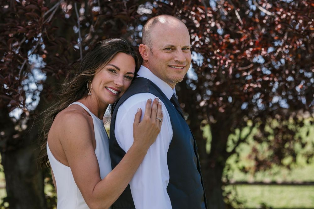 Natural light illuminates a couple during an autumn photoshoot among fall foliage.