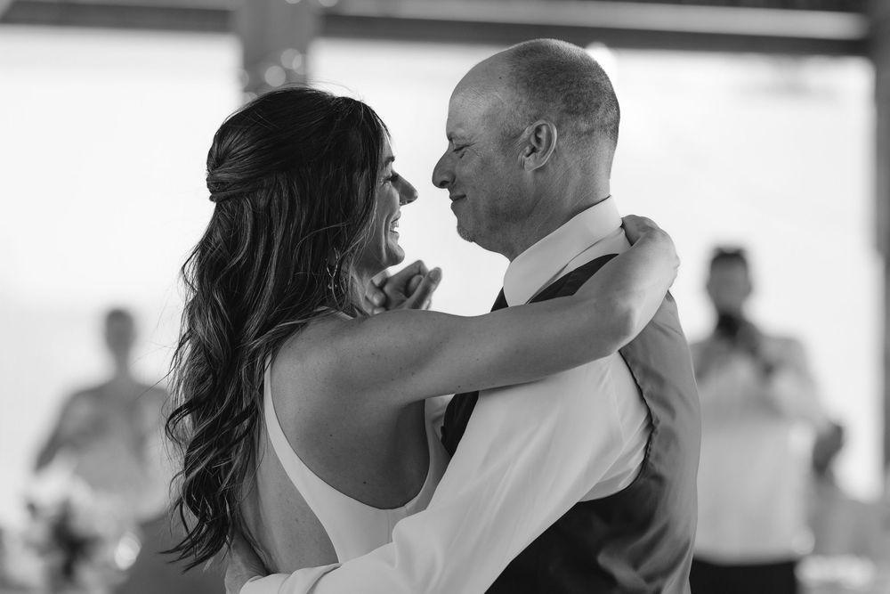 A romantic black and white moment captured during the first dance at a wedding reception.