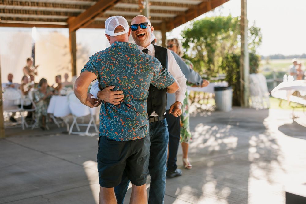 Guests mingling under a covered outdoor patio area during a wedding reception.