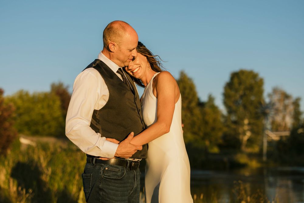 A couple sharing intimate moments during their wedding photoshoot in warm evening sunlight.