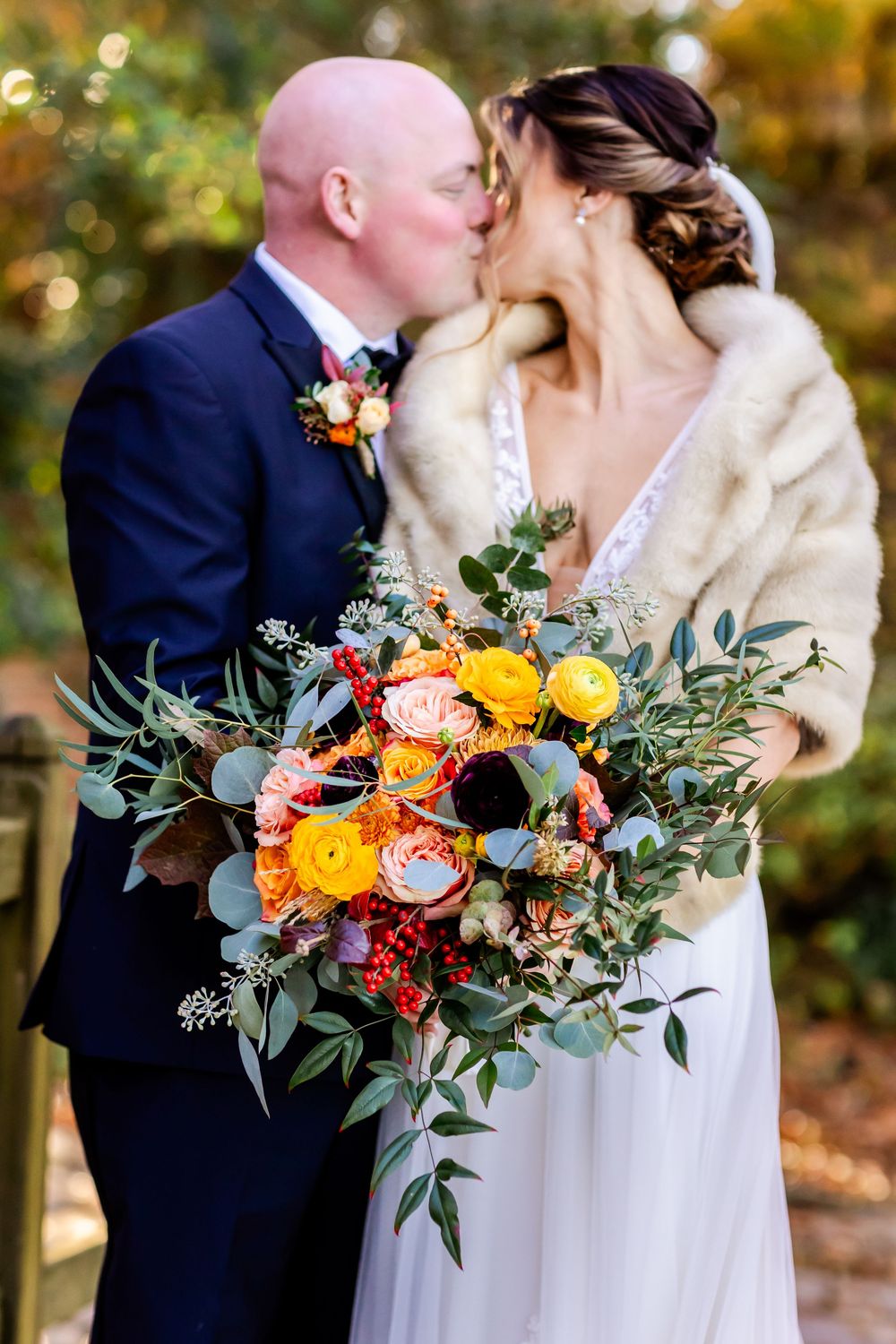 Romantic wedding photography series showcasing vibrant orange and yellow bouquet with greenery against white dress and navy suit.