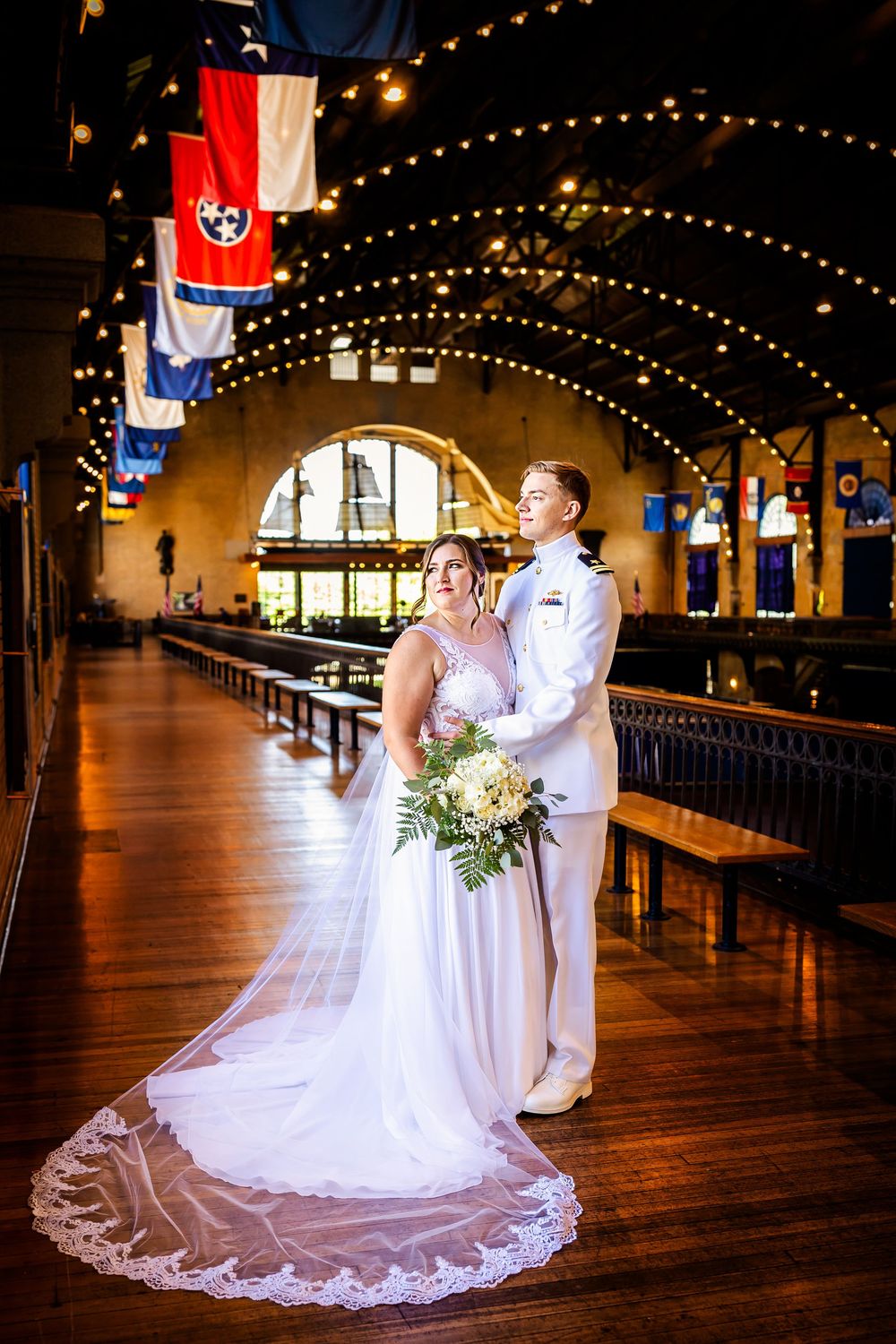 A romantic wedding ceremony scene in a rustic ballroom with twinkling string lights and wooden floors.