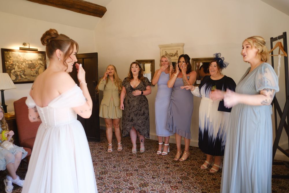 Bride doing the first look with her friends. Friends very happy and tearful. Candid photograph at Holdsworth House