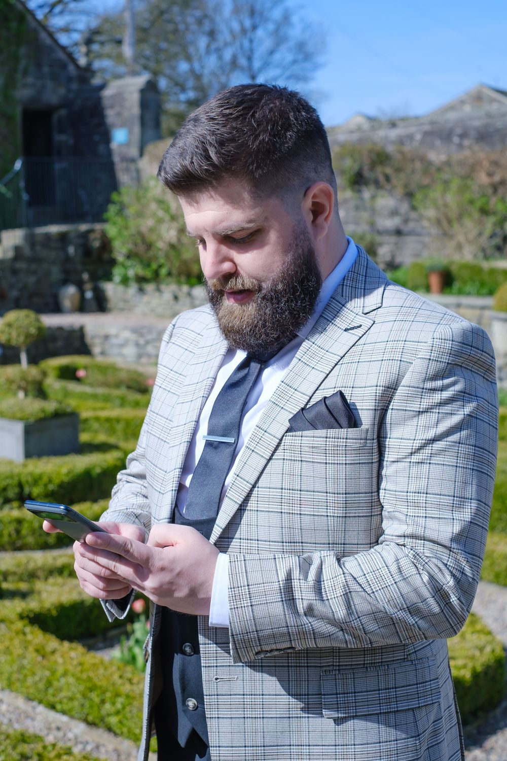 Groom checking his phone- candid photograph