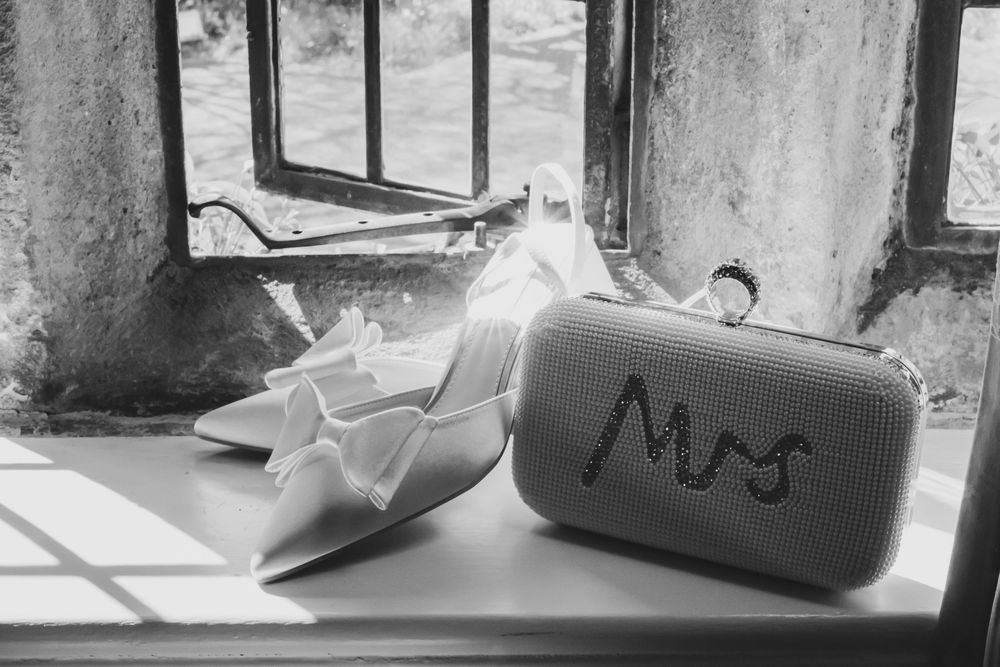 Bride's handbag and shoes on the stone windowsill by the mullion window.