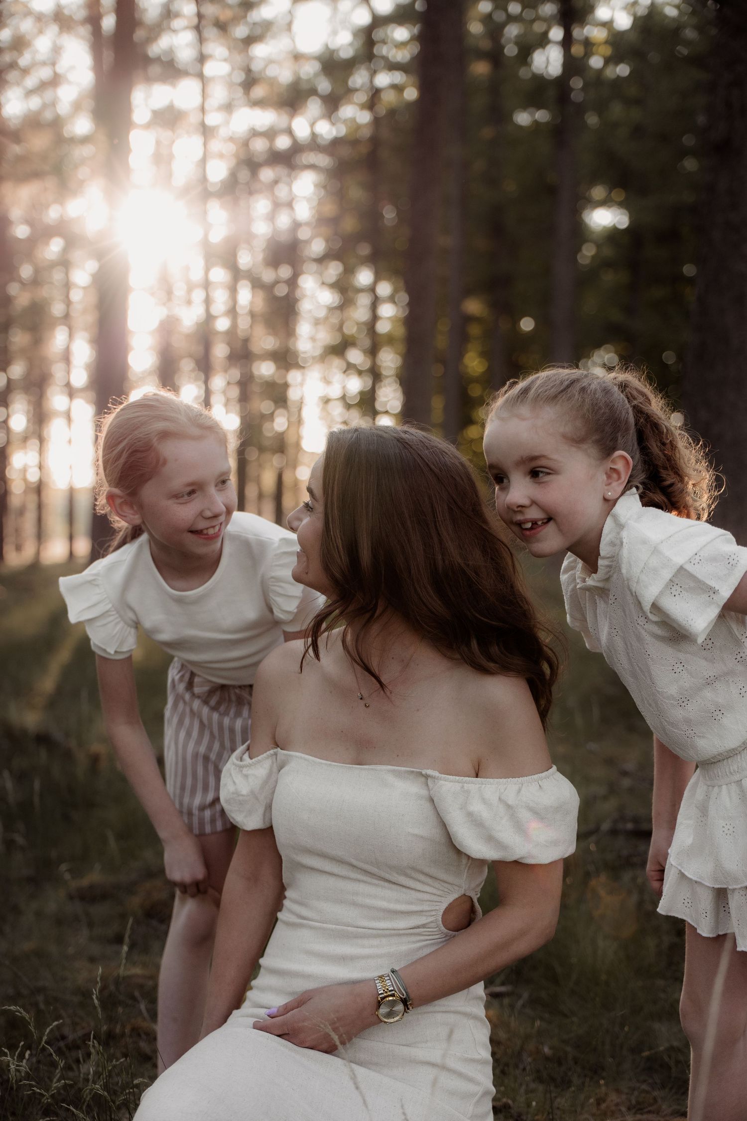 Moeder en twee dochters tijdens een liefdevolle gezinsshoot in het bos bij Helmond. Warm, spontaan en puur vastgelegd.