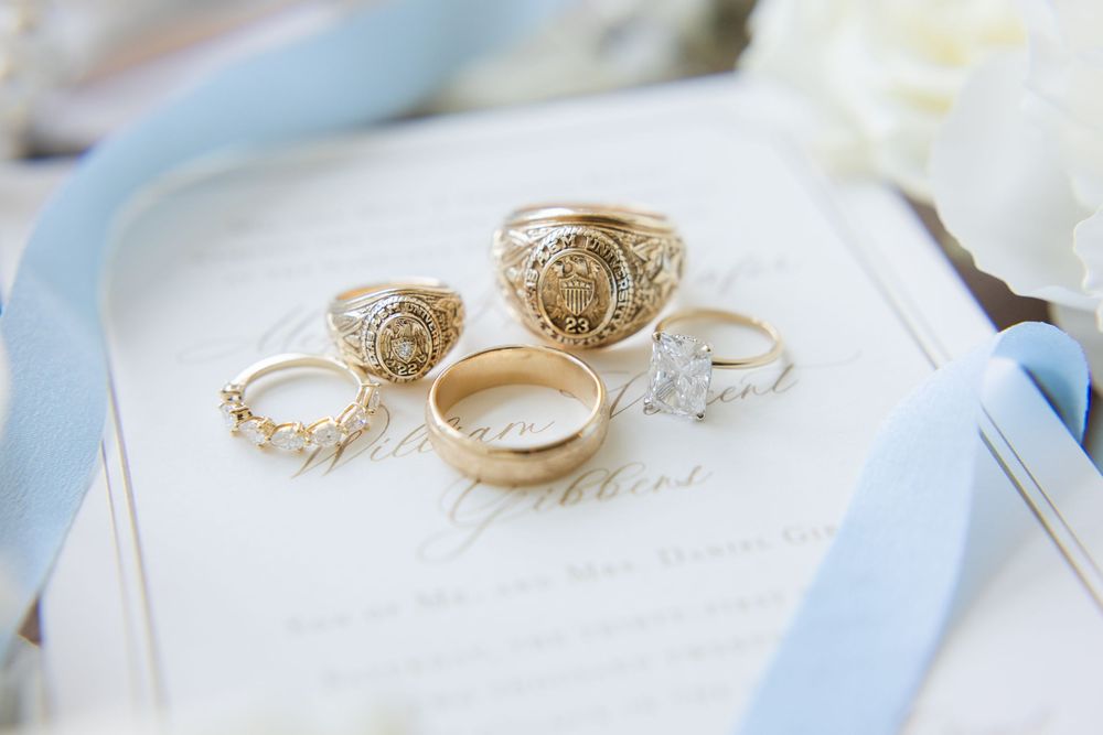 Collection of vintage-style wedding rings arranged on light blue and white fabric.