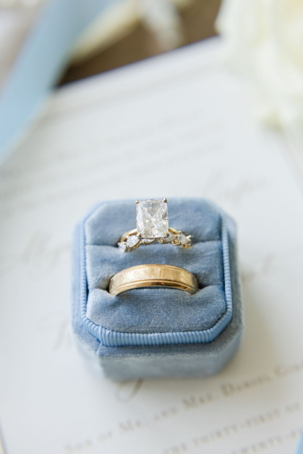 Wedding rings in light blue velvet ring box with engagement ring and wedding band.