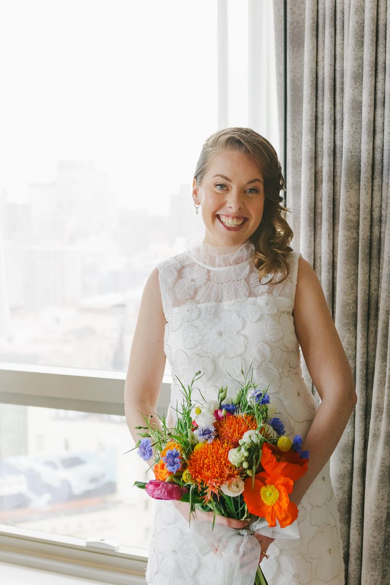 Bride posing with her bouquet, radiating joy and elegance before her intimate NYC wedding ceremony.