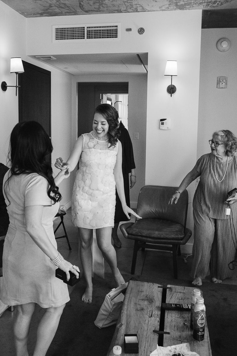 Bride getting ready with family at her NYC hotel suite, captured by small wedding photographer Paula Brearley.