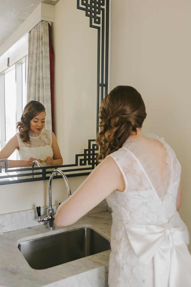Bride applying lipstick before her Jewish wedding, a soft and intimate moment captured by NYC wedding photographer Paula Brearley.