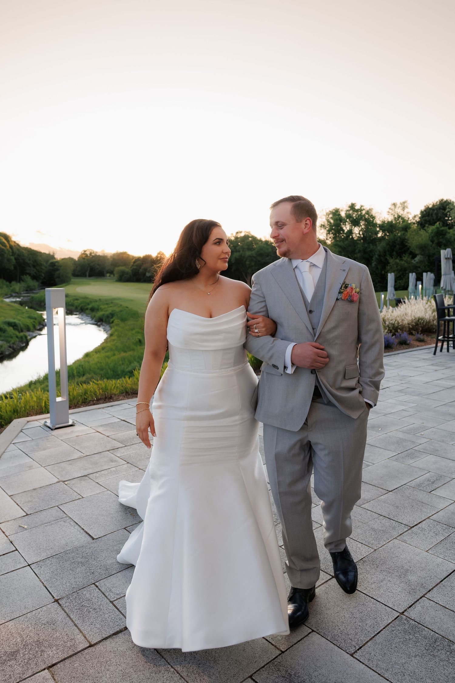 Sunset wedding portrait on a stone patio overlooking a golf course.