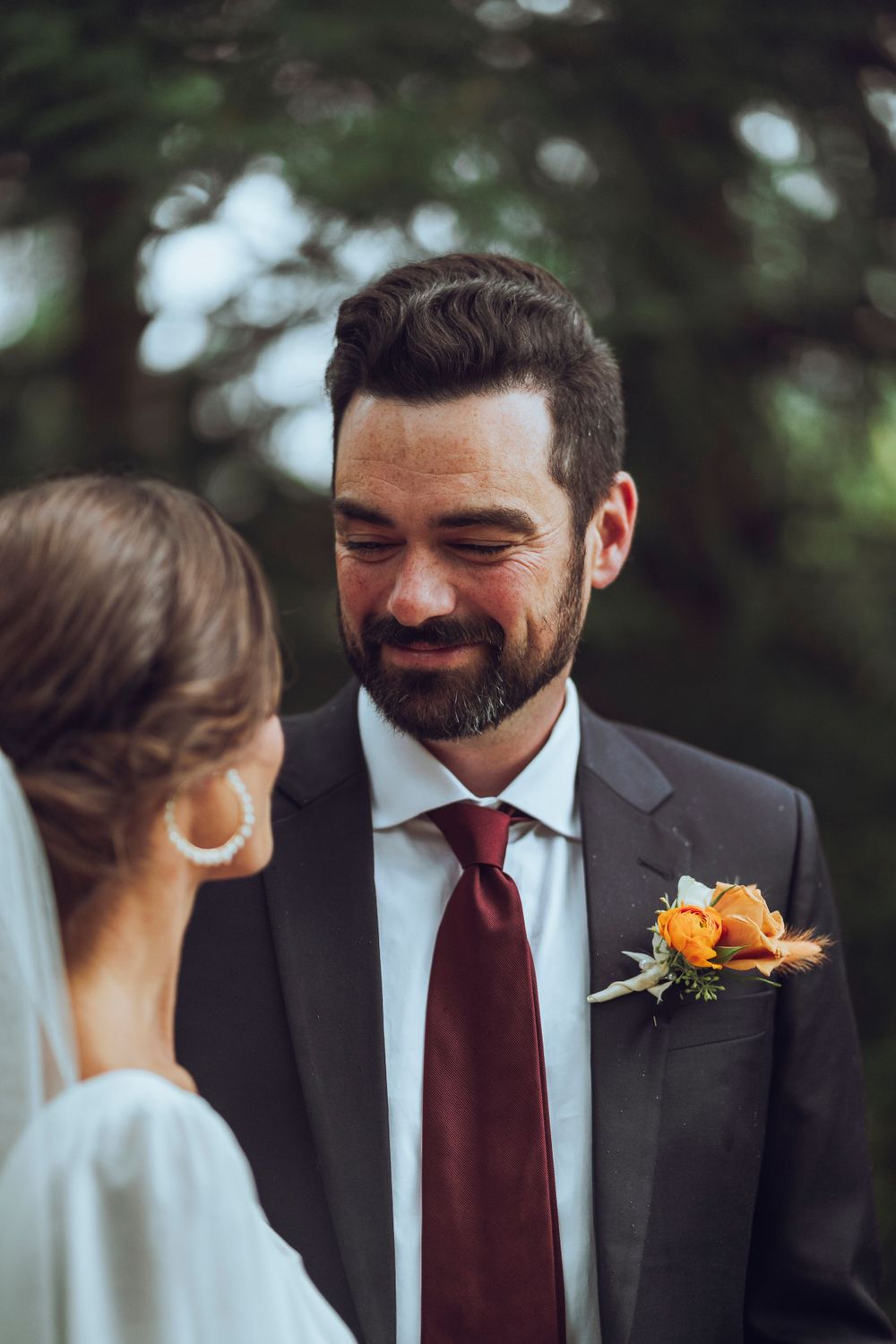 A groom smiles at his soon to be bride, capturing a romantic and joyful wedding moment.