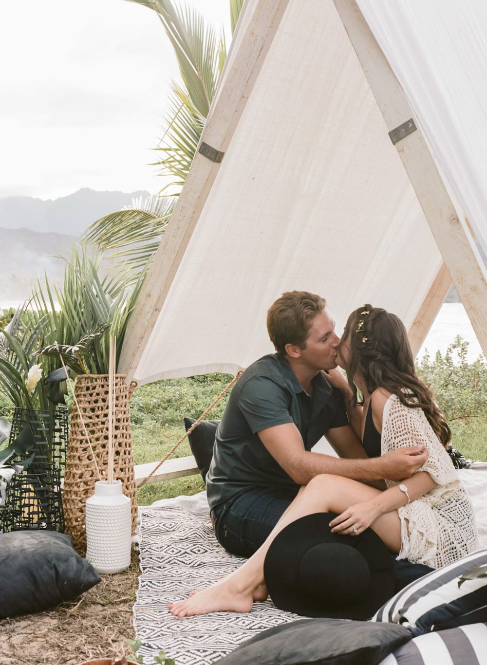 Romantic moment captured inside bohemian styled A-frame tent with mountain views.