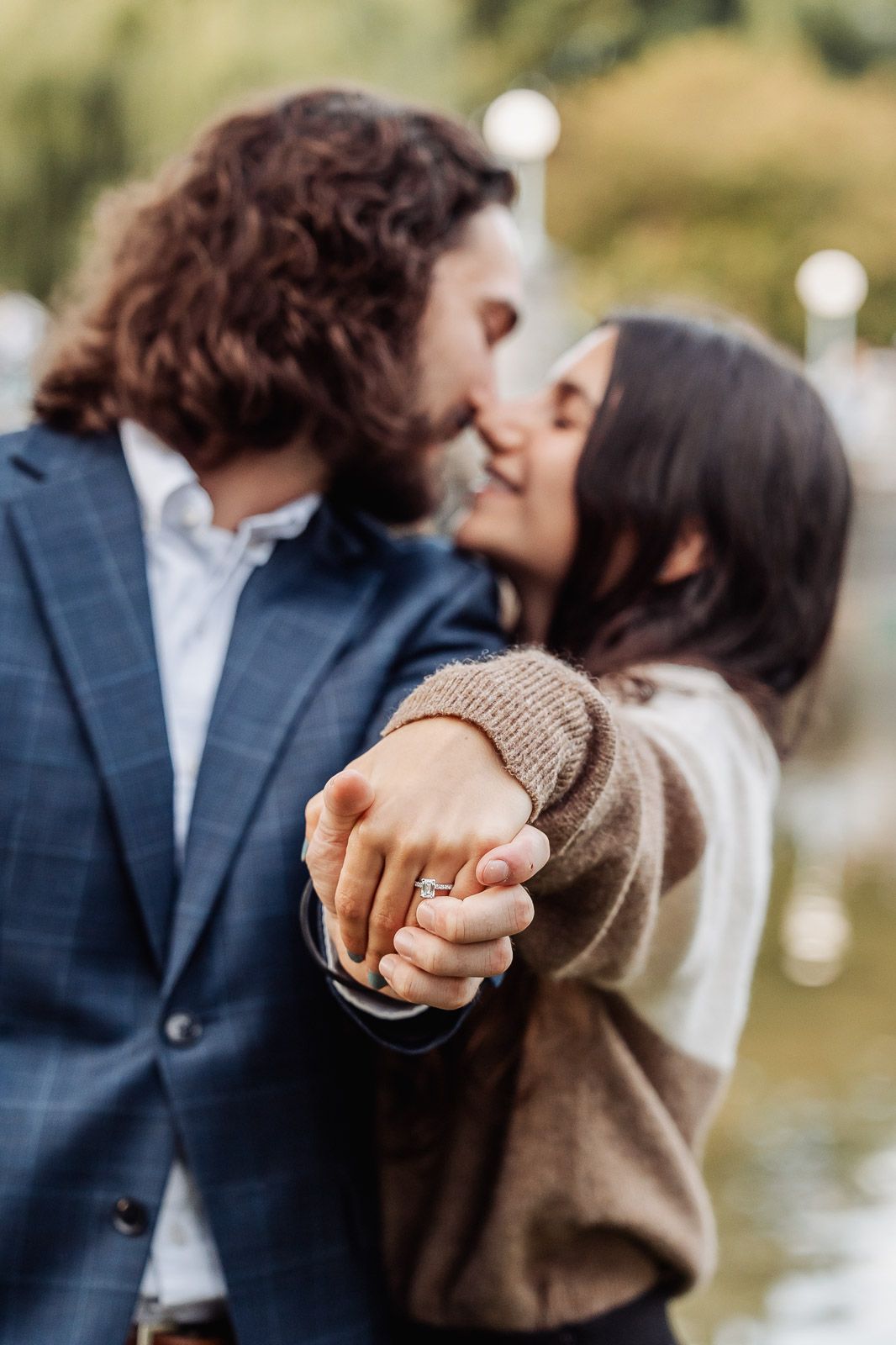 A romantic engagement moment with a ring prominently displayed during an intimate embrace.