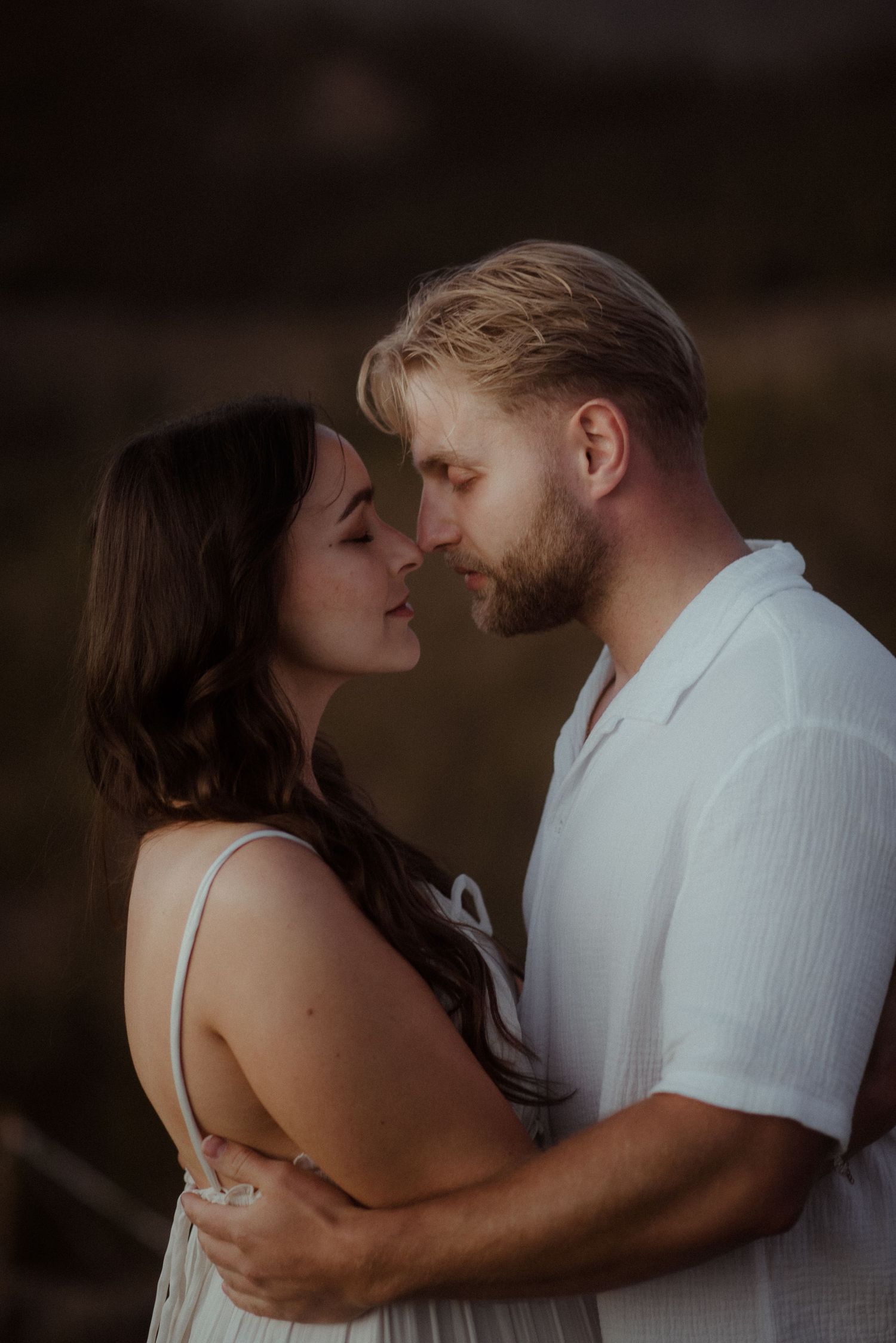 An intimate portrait showing tender affection against a dusky mountain backdrop. Tenerife Wedding Photographer at Teide.