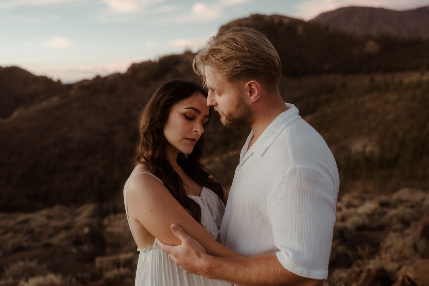 Romantic couple shares tender moment against mountainous backdrop at dusk. Tenerife Wedding Photographer at Teide.